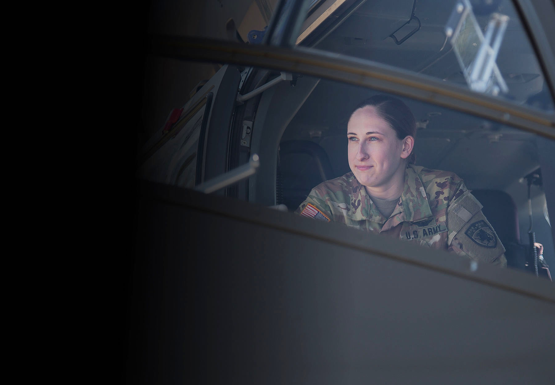 CW2 Snavely casually seated inside a parked Army helicopter