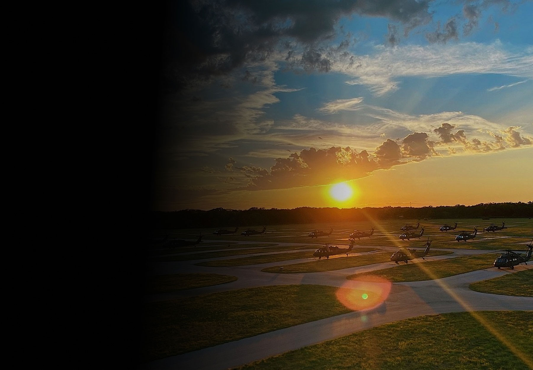SPC Yascavage seated at computer with view of runway at sunset
