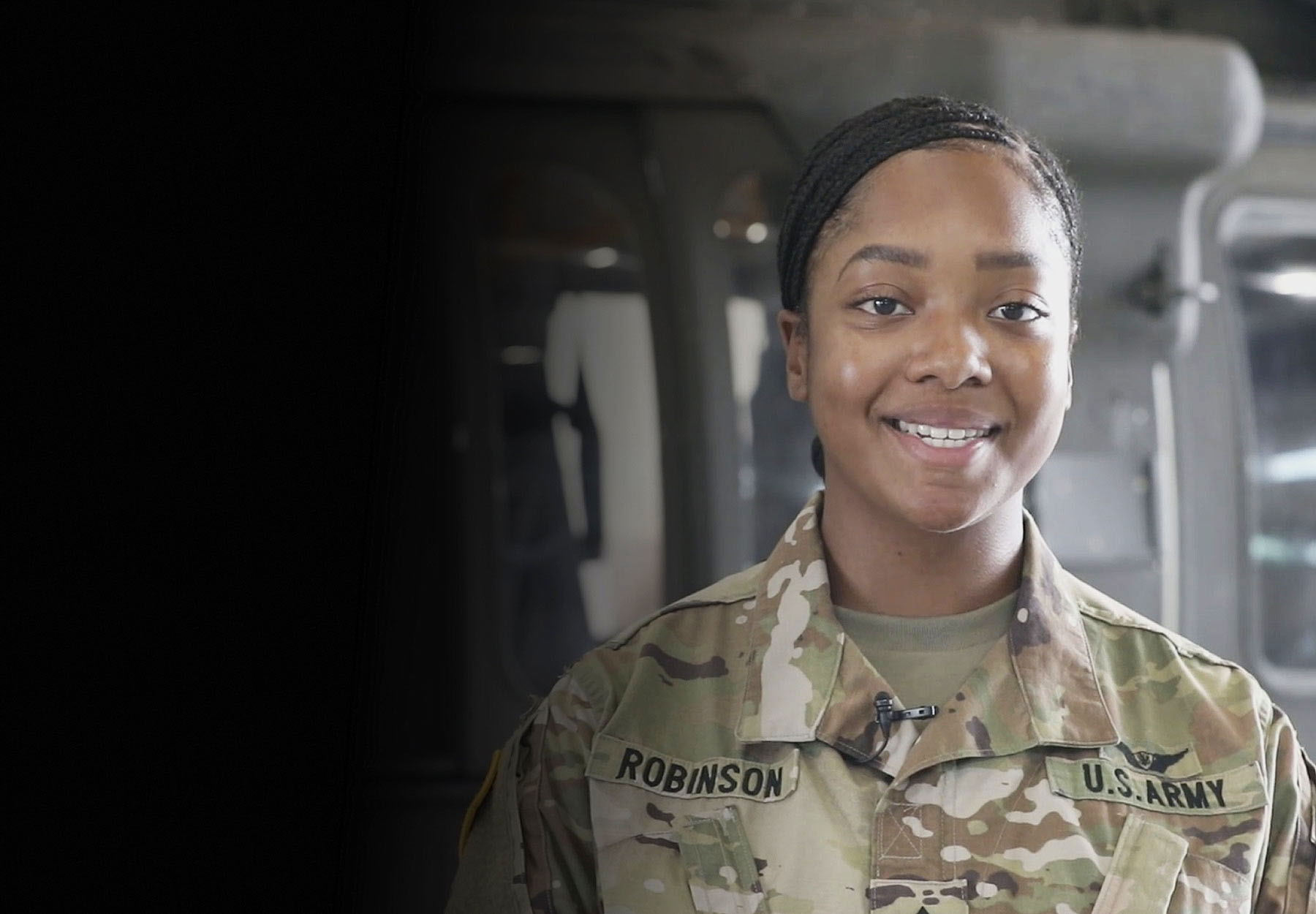 PFC Robinson standing to the side of Army helicopter